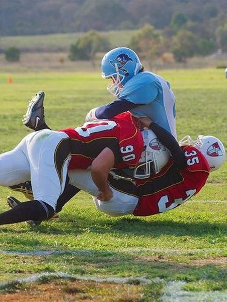Western Crusaders gridiron players tackle an opponent